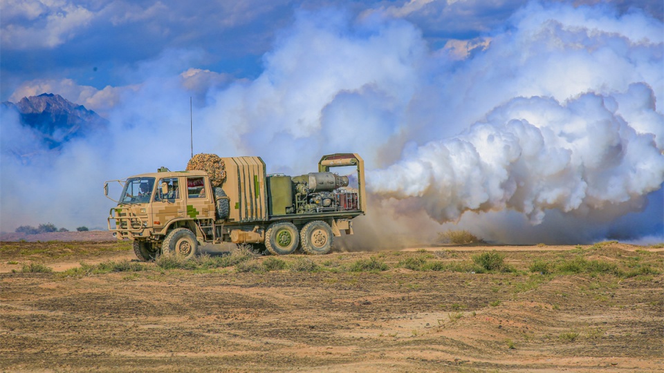 Military vehicle releases smoke in CBRN decontamination drill