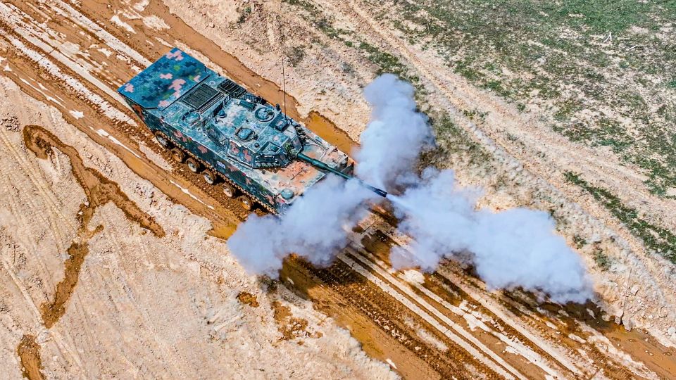 Armored vehicles fire at targets  