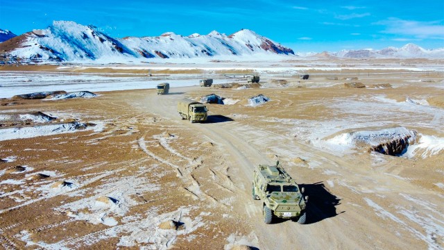 Military vehicles maneuver in real-combat training