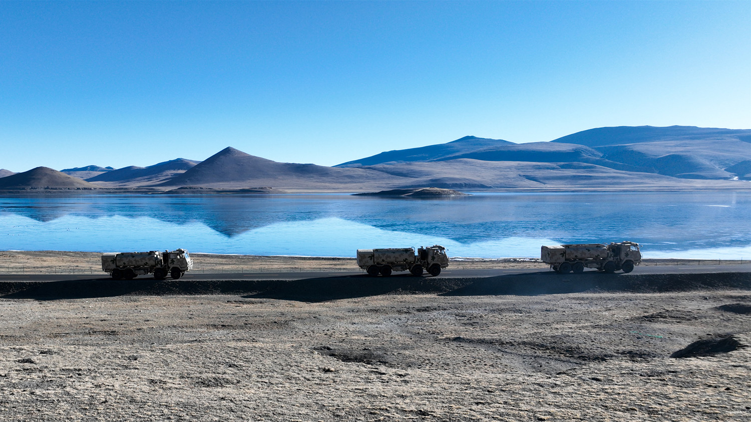 Military trucks maneuver on plateau 