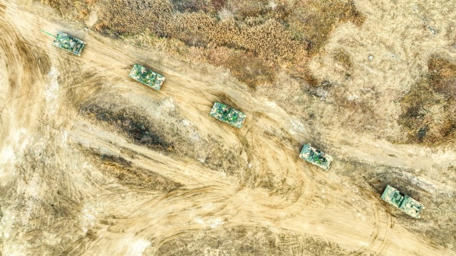 Armored vehicles rumble through field