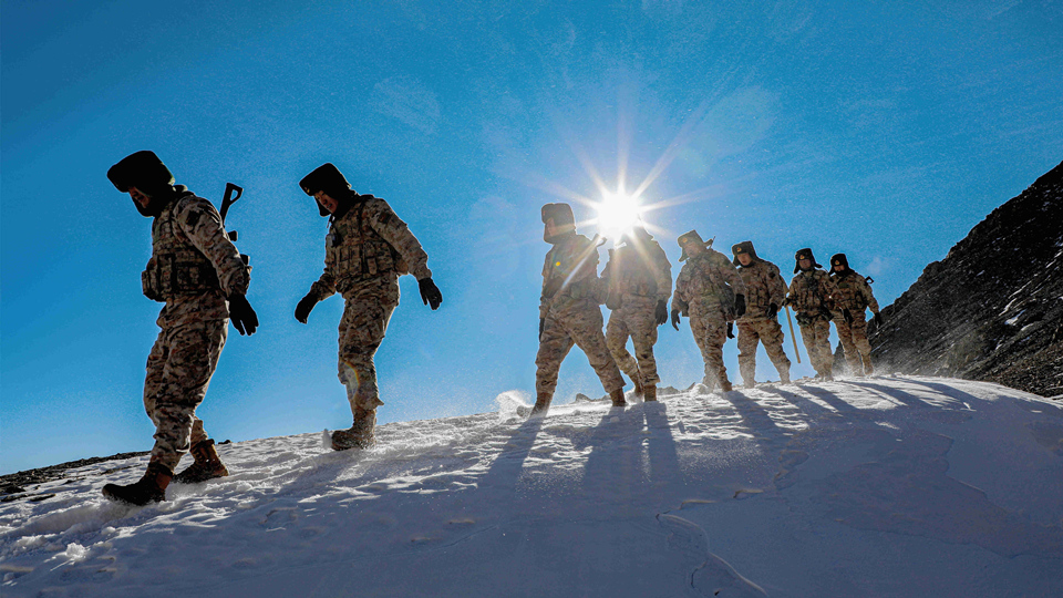 Border defense troops patrol in snowy mountain area