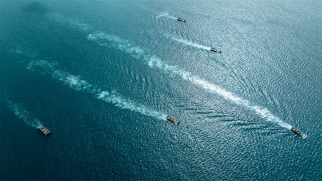 Amphibious infantry fighting vehicles steam in formation