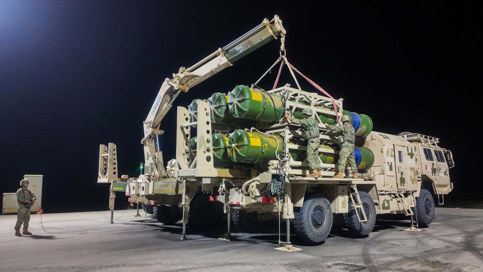 Soldiers hoist and load HQ-16 missiles